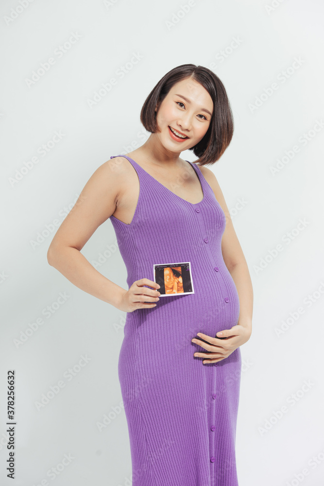 pregnant woman shows a ultrasound photo of her future baby.