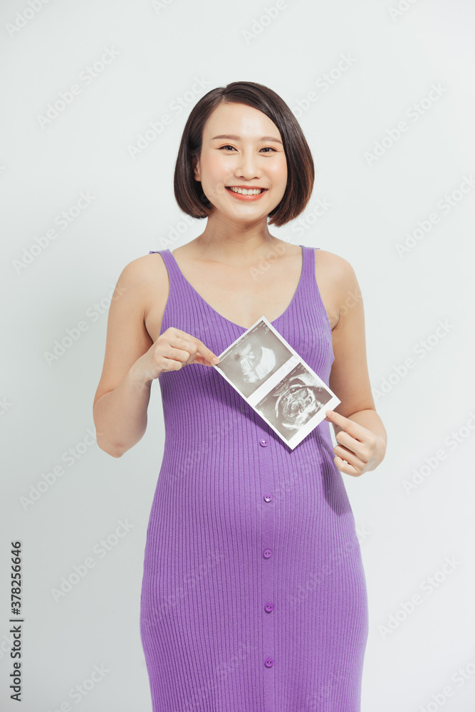 pregnant woman shows a ultrasound photo of her future baby.