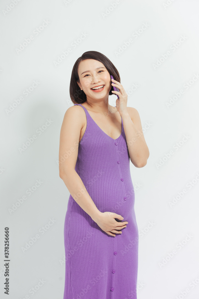 Portrait of latin pregnant woman talking on the phone against white background. Communication and pr