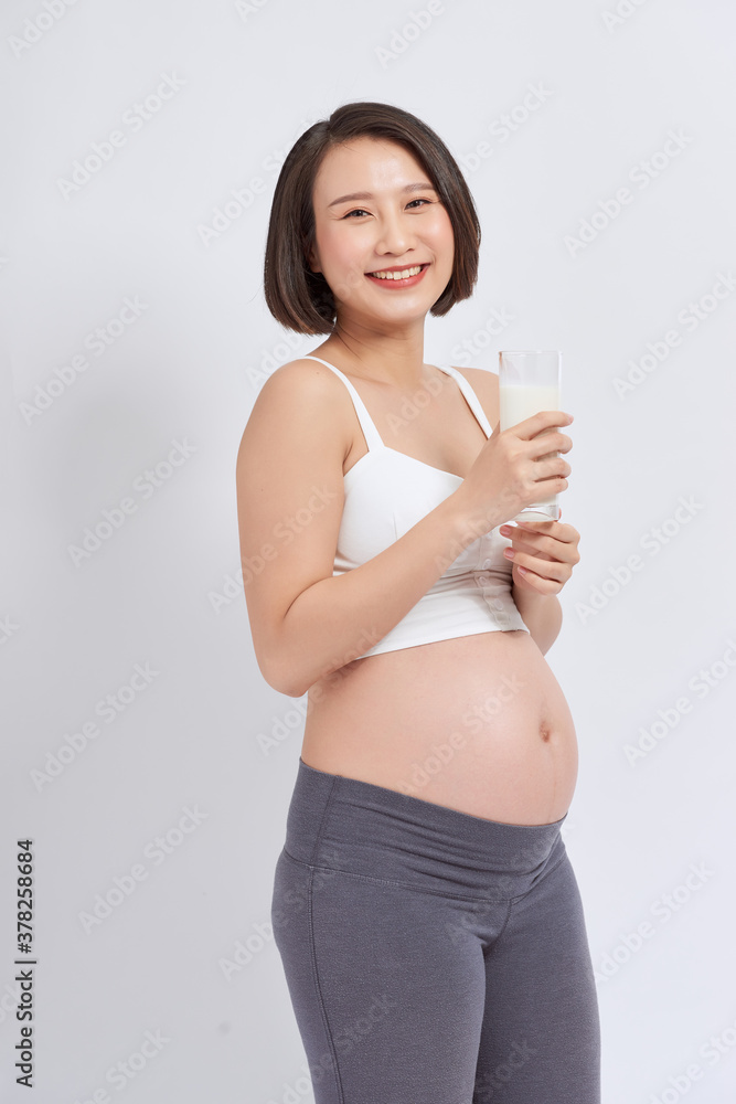 Pregnant young asian woman with a glass of milk in hand.