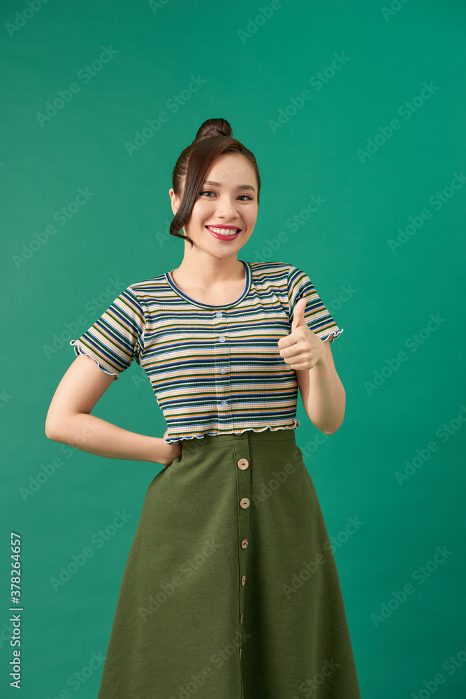 Cheerful smiling beautiful woman showing thumbs up or like hand sign gesture,