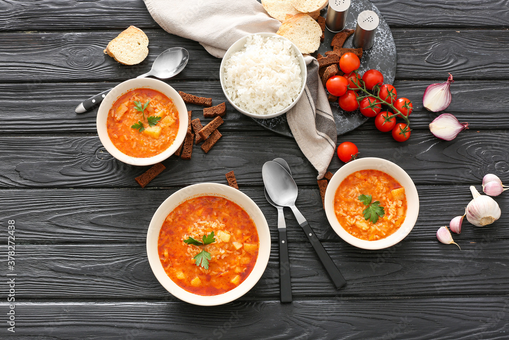 Bowls of tasty rice soup on table