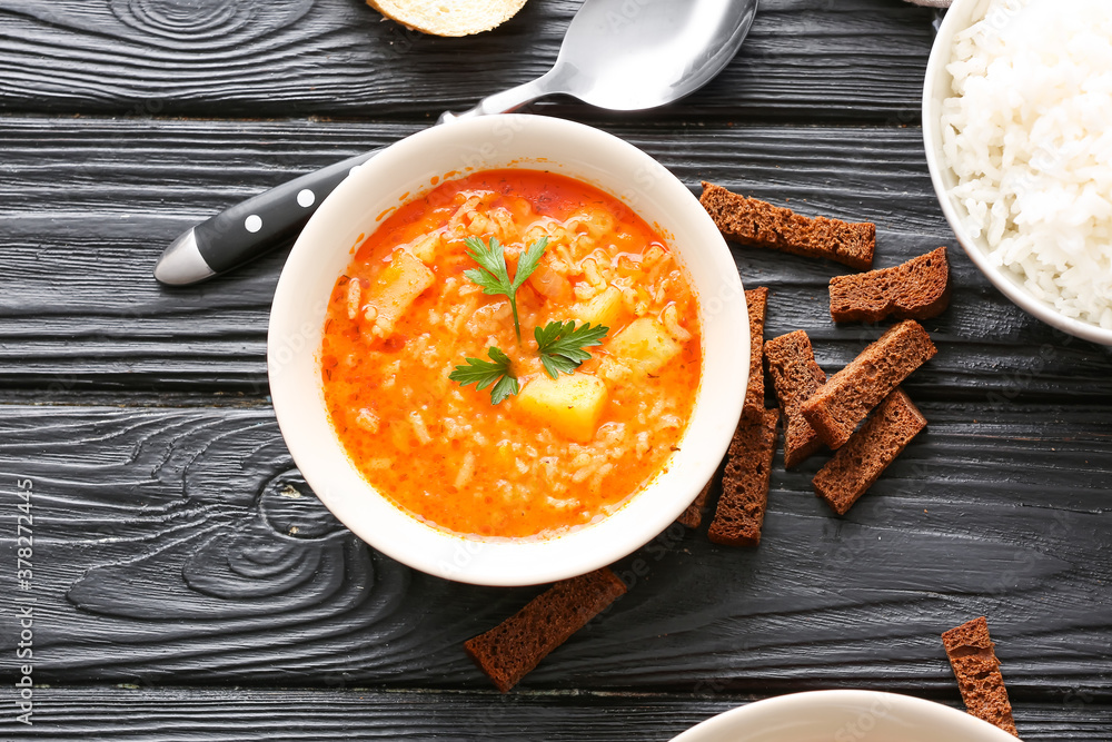 Bowl of tasty rice soup on table