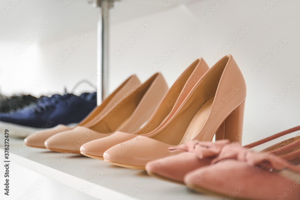 Shelf with stylish shoes in modern store