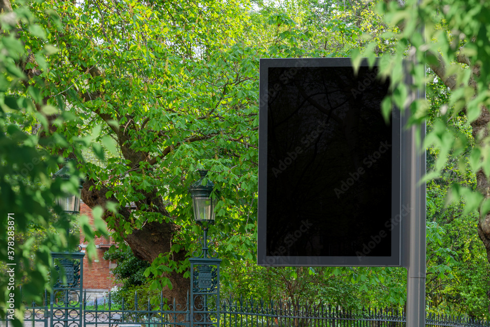 Billboard Mockup in a city with natural landscape. Parisian style hoarding on a pole close to a park