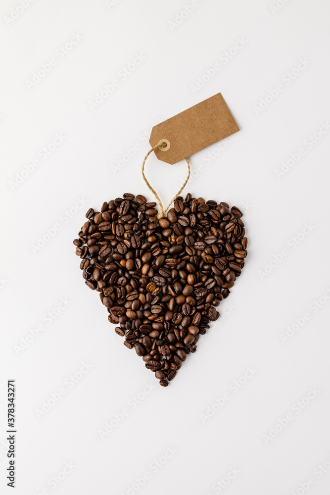 Coffee beans in shape of heart on white background, flat lay