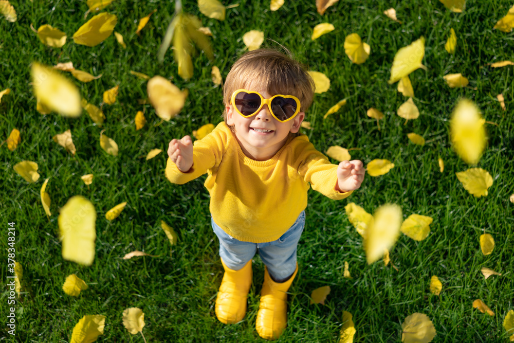 Happy child having fun outdoor in autumn park