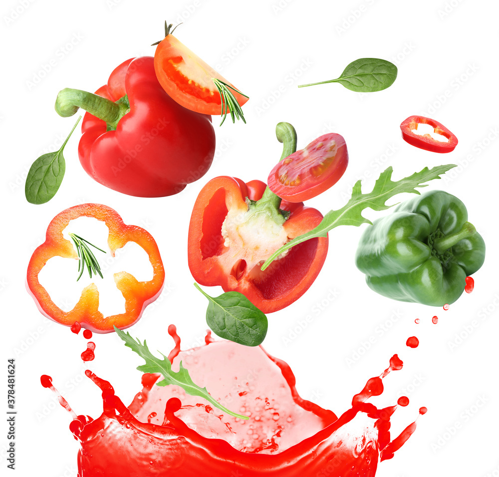 Splash of fresh vegetable juice and flying ingredients on white background