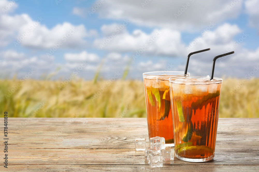 Glasses of tasty cold ice tea on table outdoors