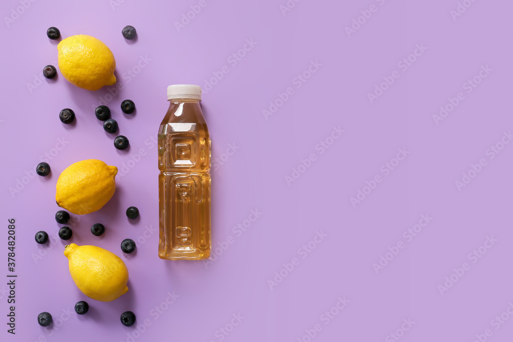 Bottle of fresh ice tea and ingredients on color background