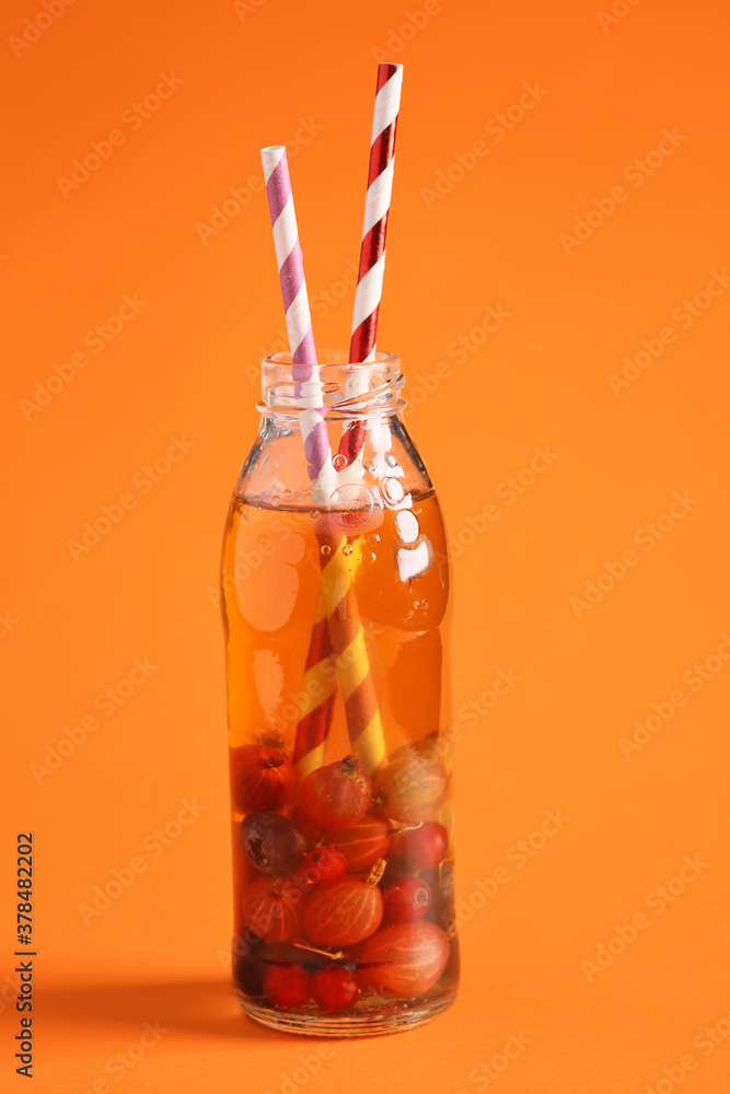 Bottle of fresh ice tea on color background