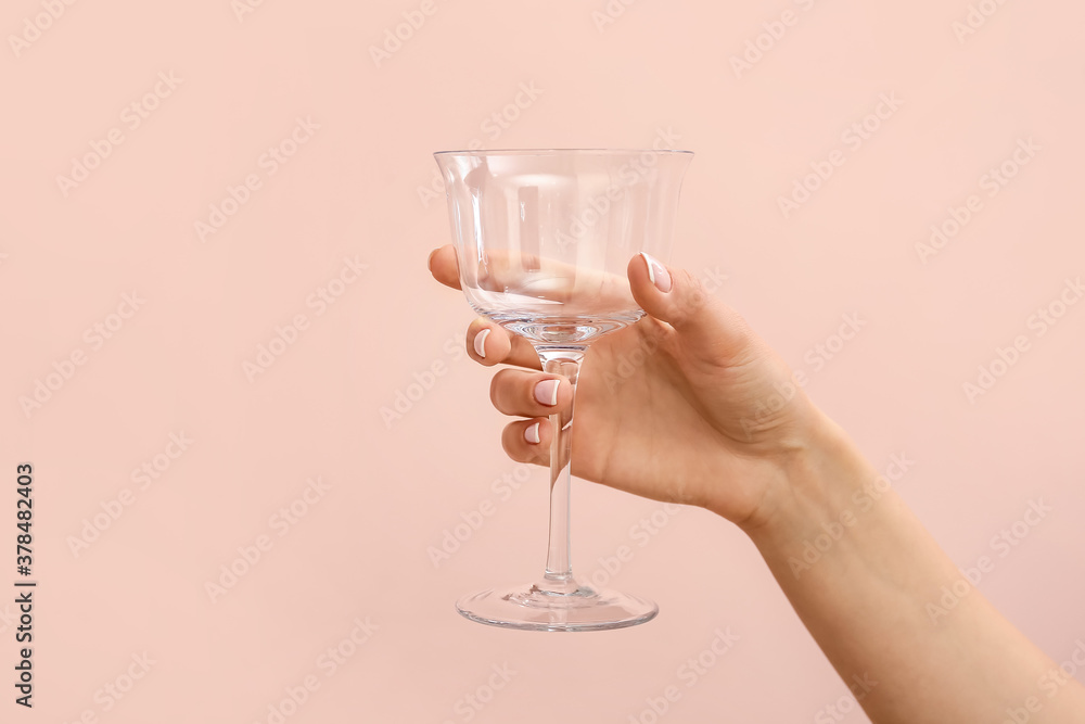 Hand with empty glass on color background