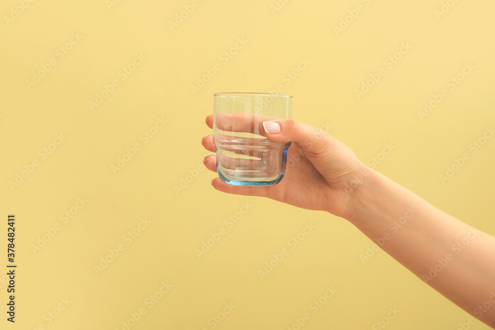 Hand with empty glass on color background