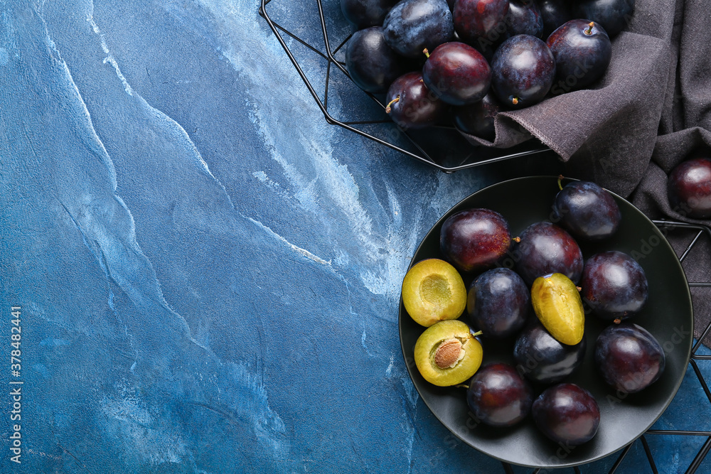 Composition with ripe plums on table