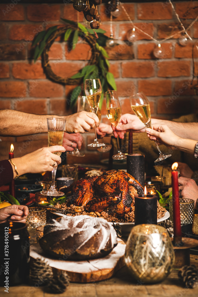 Family celebrating Christmas or New Year. Peoples hands making cheers with glasses of champagne over