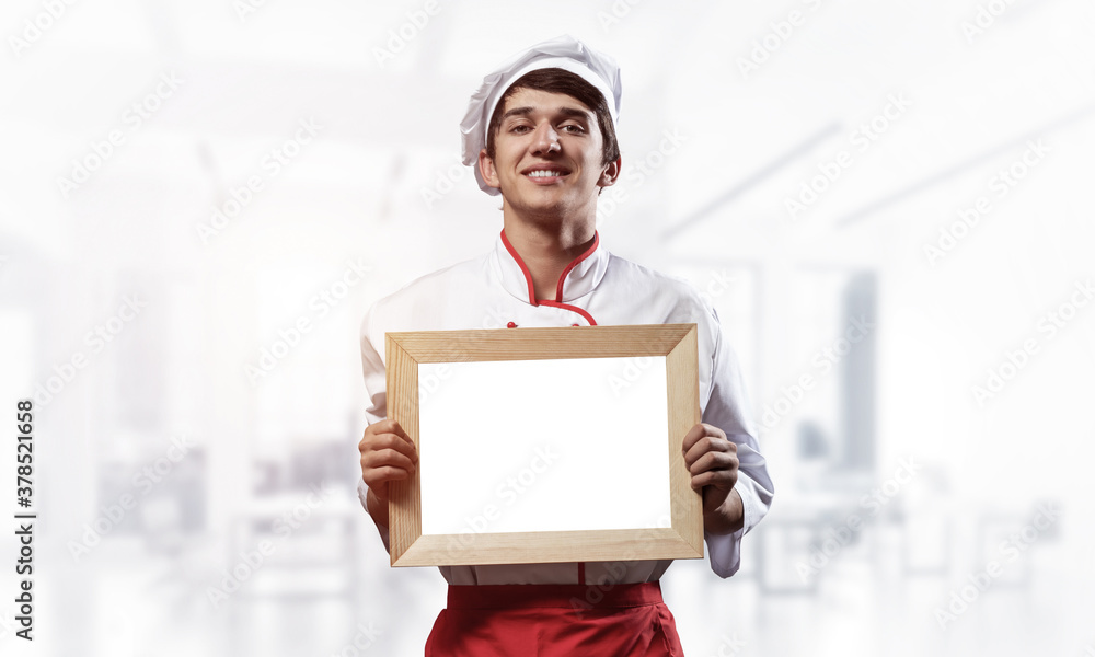 Young male chef standing near cooking table