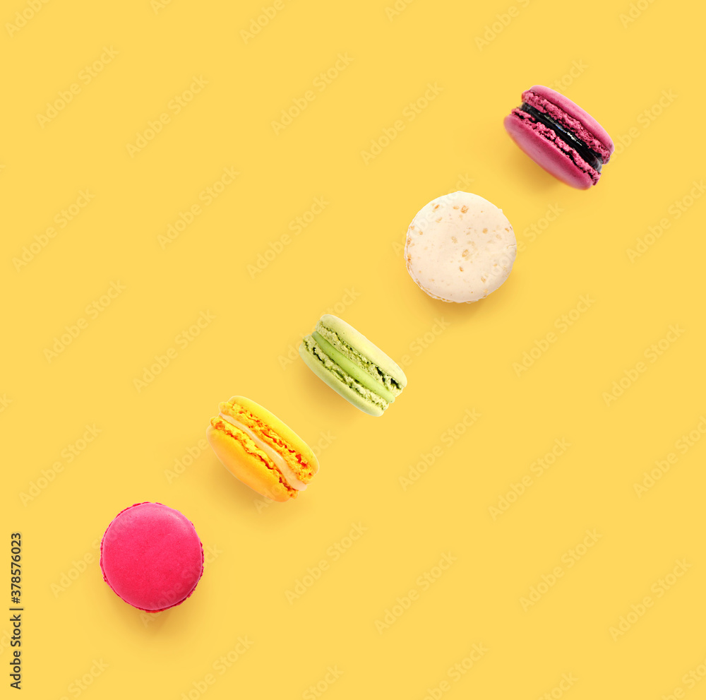 Creative layout made of macaroons on the yellow background. Flat lay. Food concept.