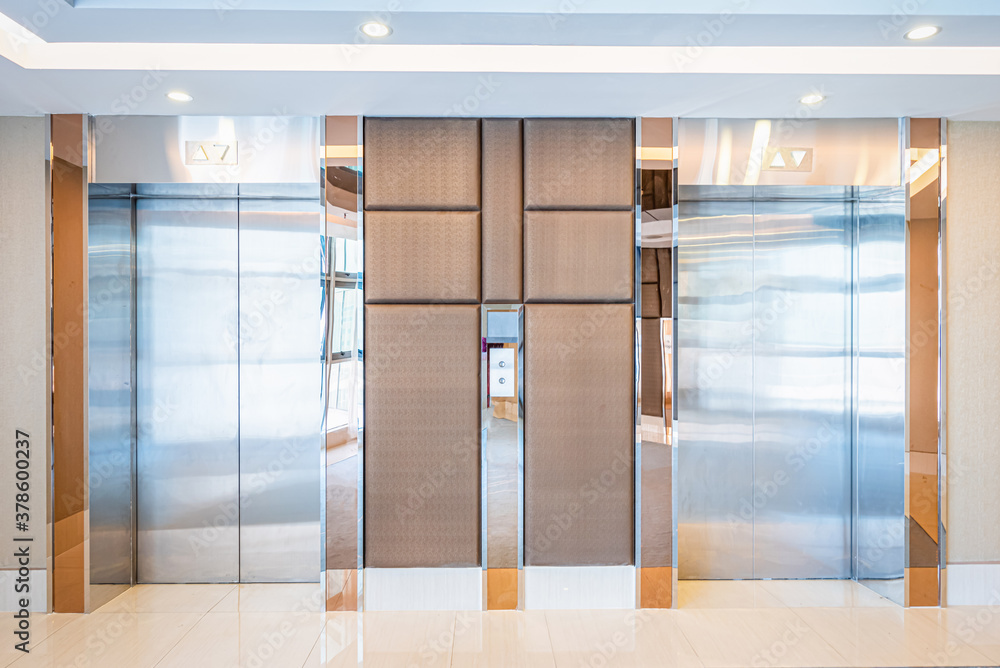 Modern steel elevator cabins in a lobby Hotel or office building.