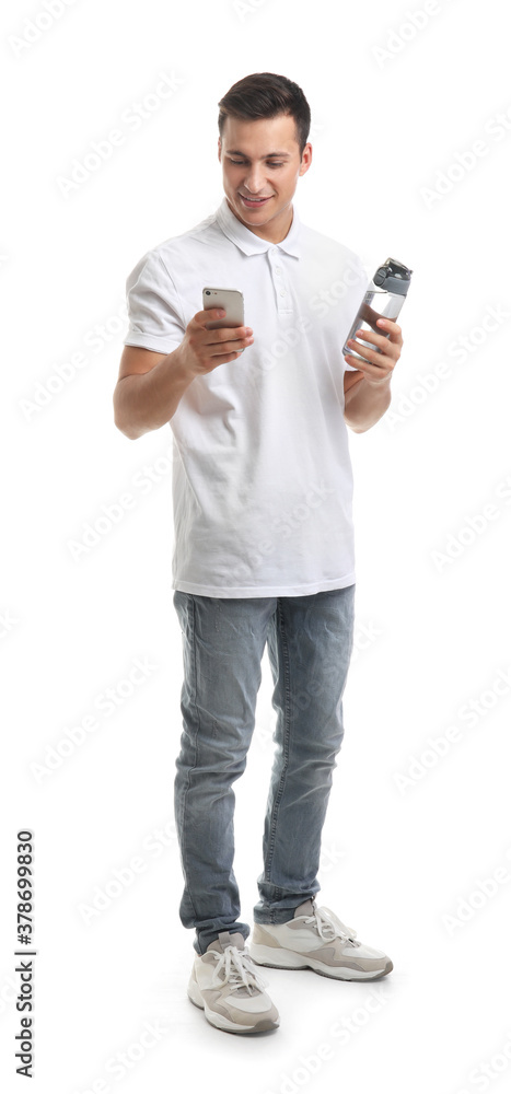 Young man with bottle of water and mobile phone on white background