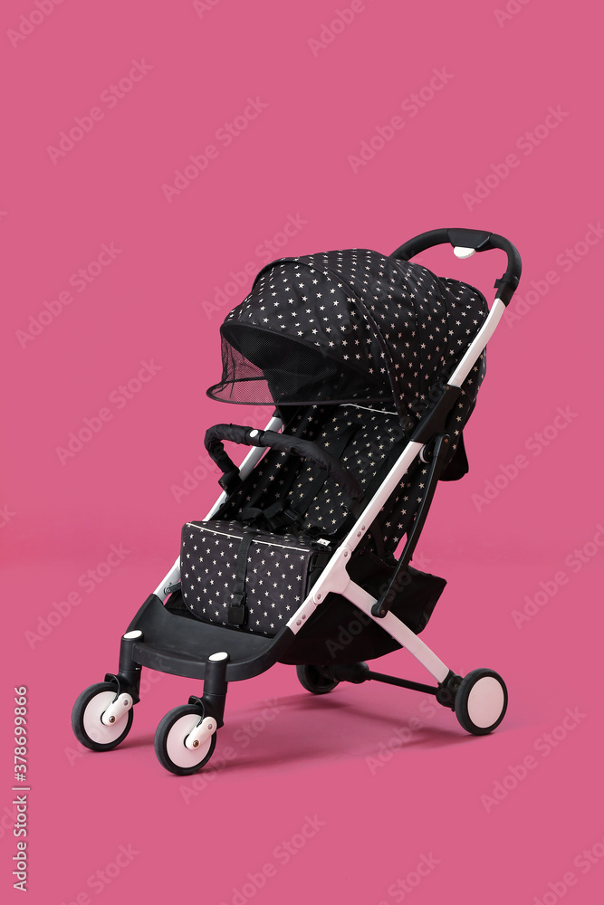 Modern baby stroller on color background