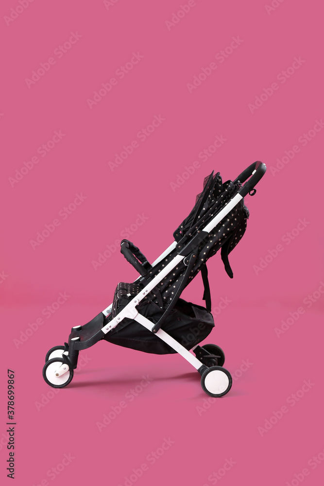 Modern baby stroller on color background