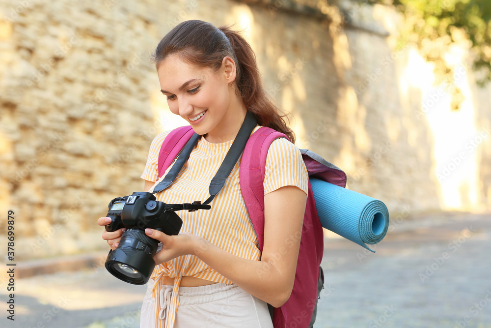 Female tourist taking photo on city street