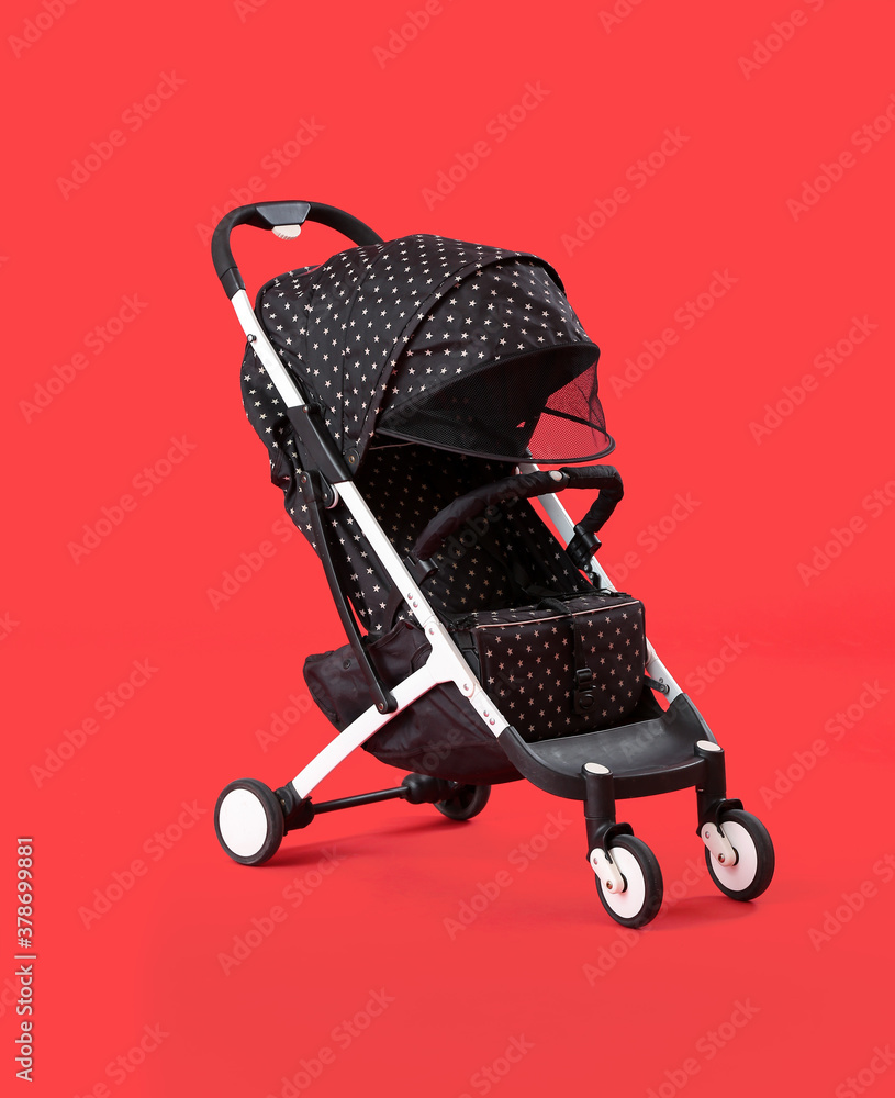 Modern baby stroller on color background