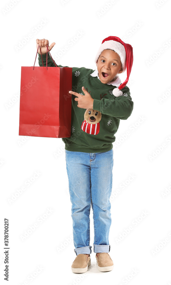 Cute African-American boy in Santa hat and with shopping bag on white background