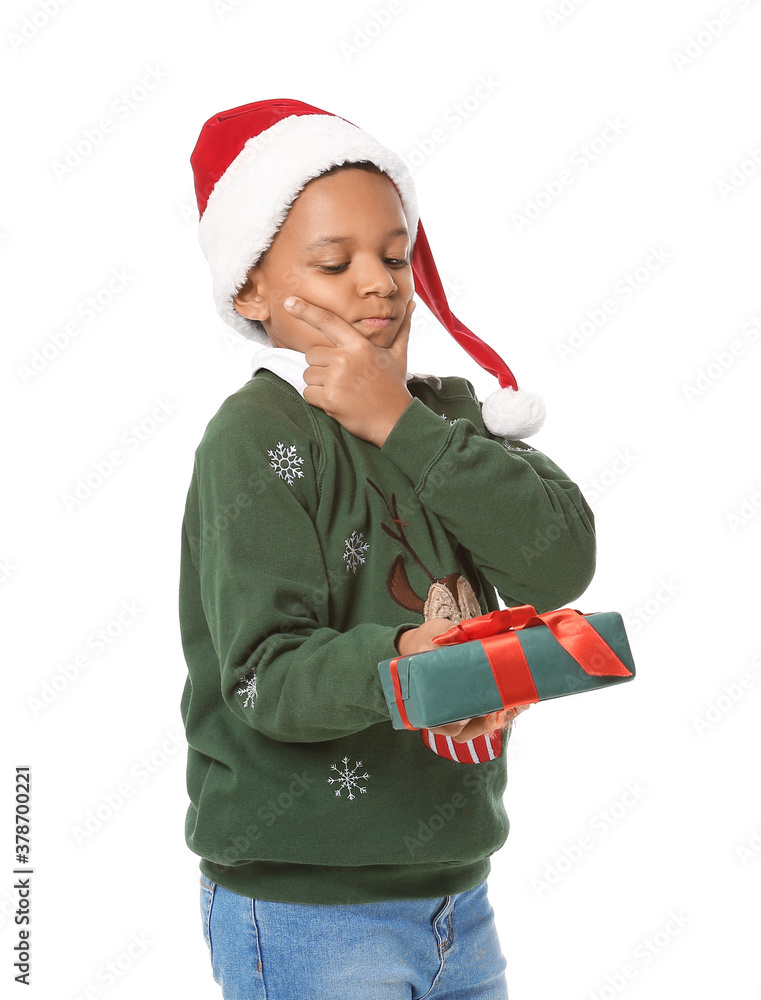 Cute African-American boy in Santa hat and with Christmas gift on white background