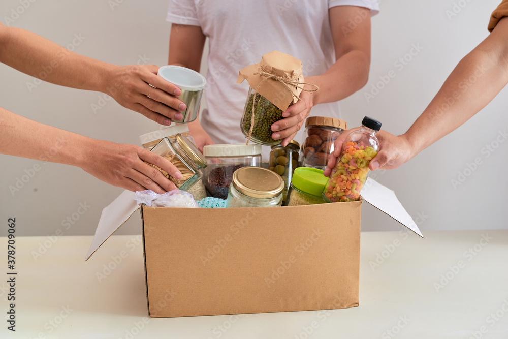 People makes foodstuffs out of donation box on table