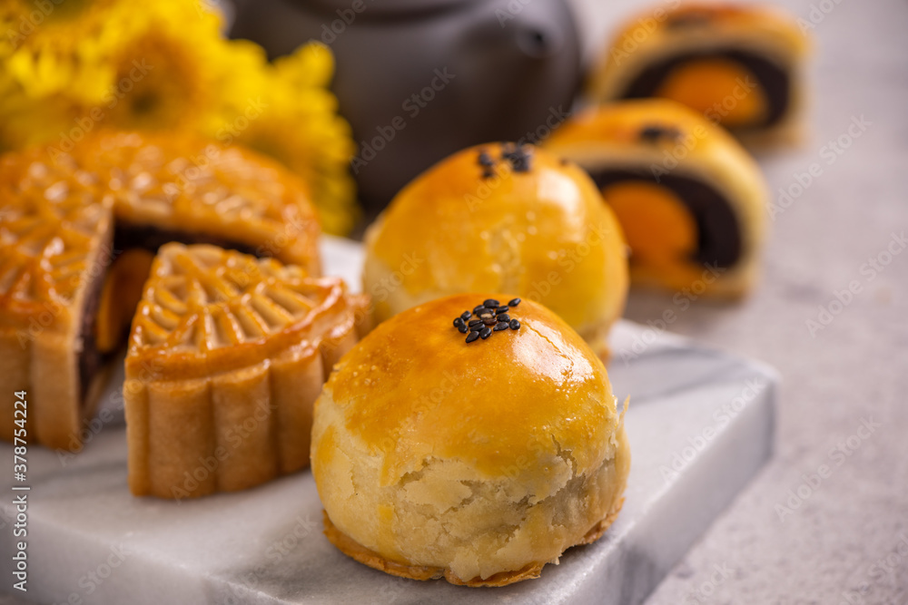 Tasty baked egg yolk pastry moon cake for Mid-Autumn Festival on bright cement table background. Chi