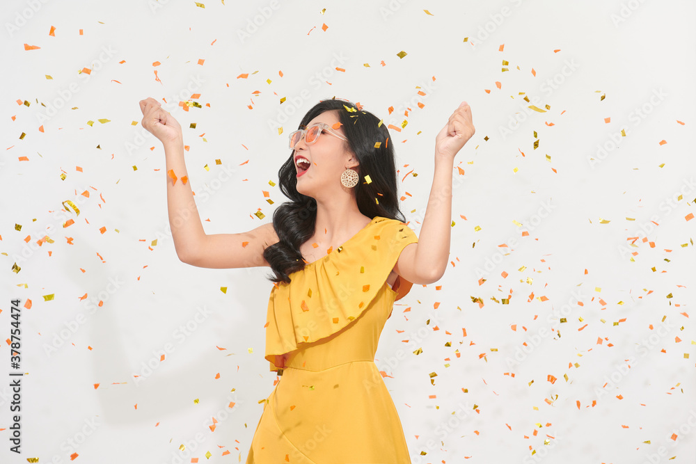 Beautiful happy woman at celebration party with confetti falling everywhere on her. Birthday or New 