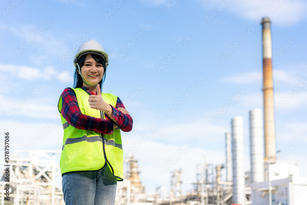 Asian woman engineer arm crossed and thumb up with confident looking forward to future with oil refi