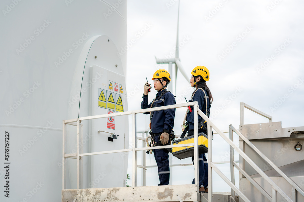 Asian man and woman Inspection engineers preparing and progress check of a wind turbine with safety 