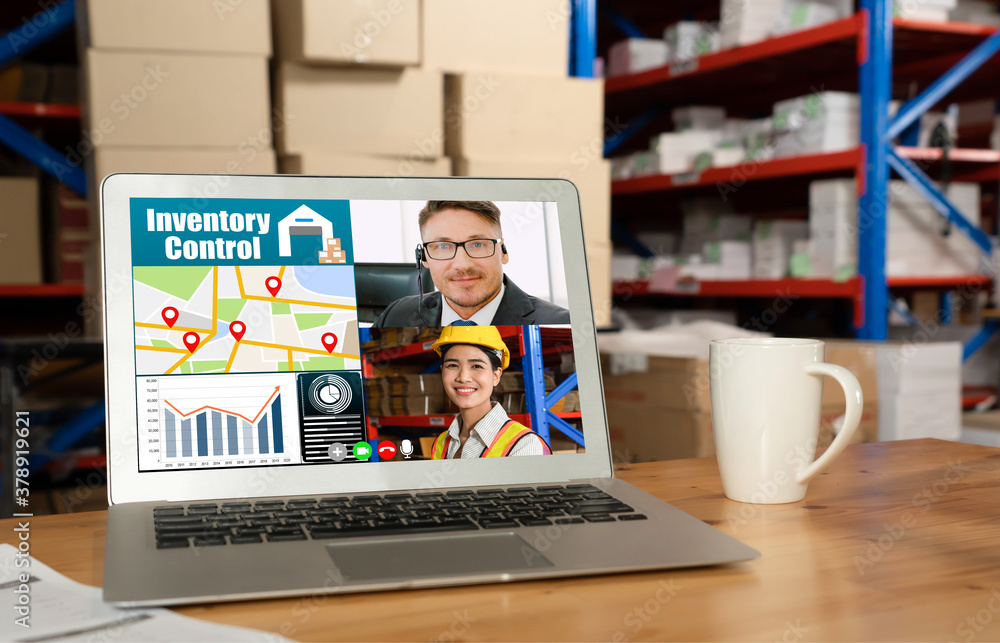 Warehouse staff talking on video call at computer screen in storage warehouse . Online software tech