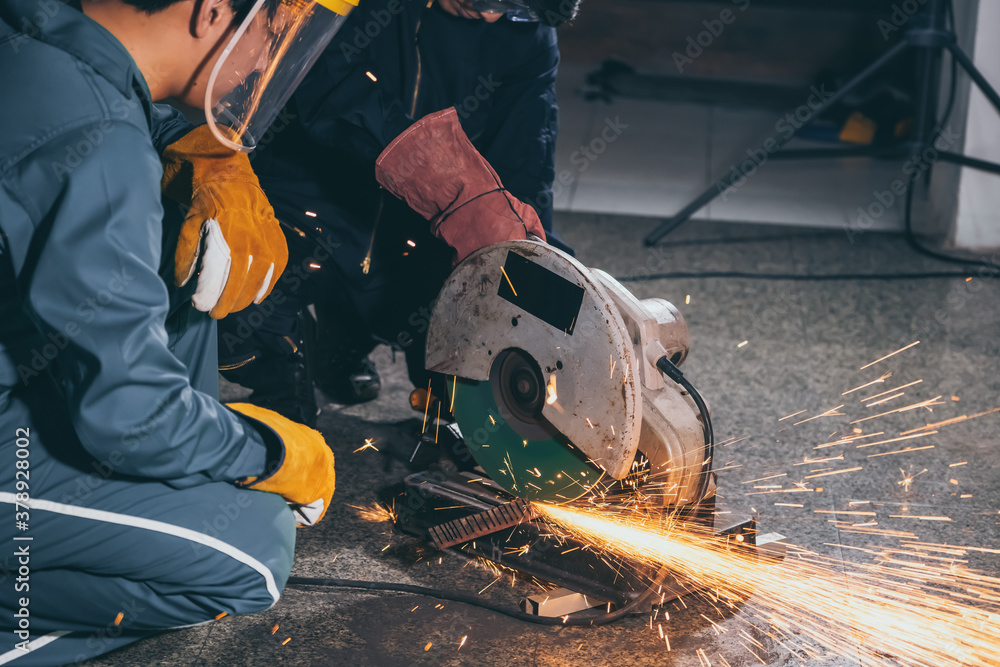 Professional mechanic man is cutting steel metal with rotating carbon blade cutter. Steel industry a