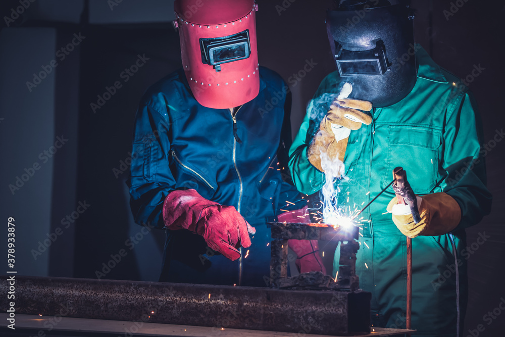 Metal welding steel works using electric arc welding machine to weld steel at factory. Metalwork man