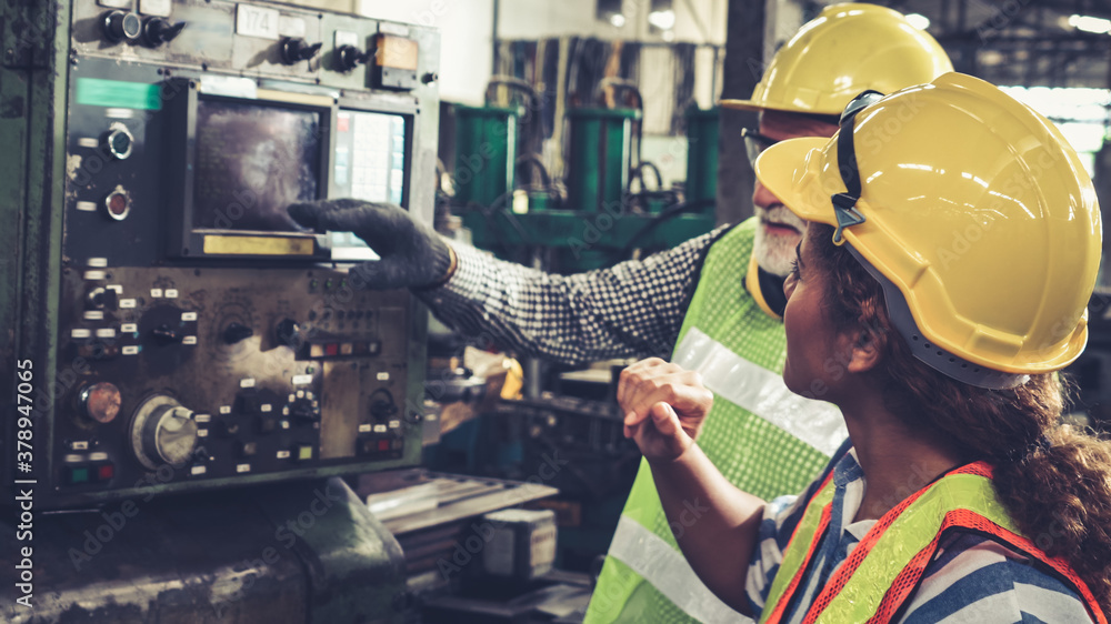 Group of factory workers using machine equipment in factory workshop . Industry and engineering conc