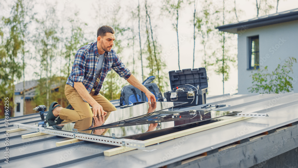 Caucasian Man in Checkered Shirt is Installing Black Reflective Solar Panels on a Metal Basis. He Wo