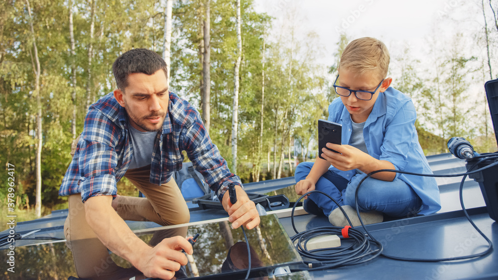 Father and Son Installing Solar Panels to a Metal Basis. They Work with Wiring on a House Roof on a 