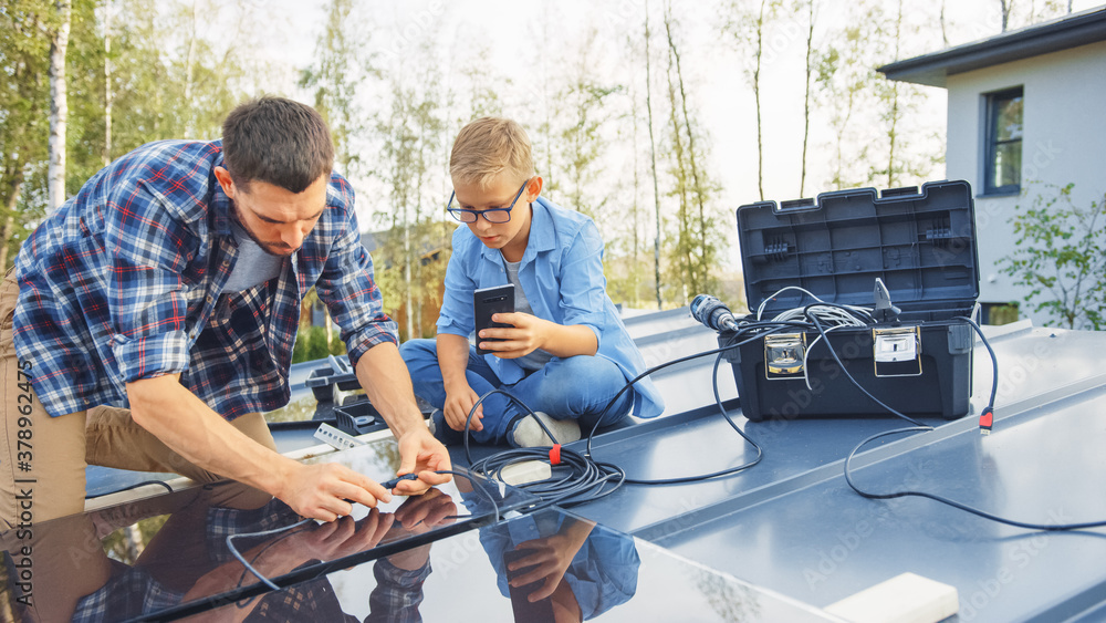 Father and Son Installing Solar Panels to a Metal Basis. They Work with Wiring on a House Roof on a 