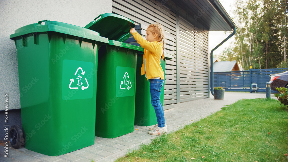 Young Girl is Throwing Away an Empty Plastic Bottle into a Trash Bin. She Uses Correct Garbge Bin Be