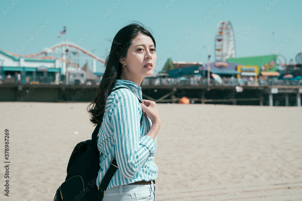 beautiful asian japanese woman backpacker walking on sandy beach outdoor on sunny day. side view of 