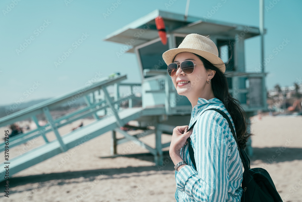 bokeh view lifeguard tower in Santa Monica on sunny day in California USA. happy smiling young girl 