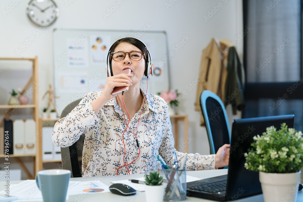 Office life rhythm regular concept. startup businesswoman in headphones sit office listen music sing