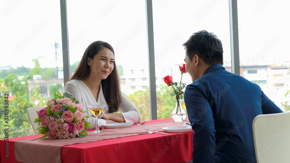 Romantic couple giving gift to lover at restaurant . Happy couple lifestyle .