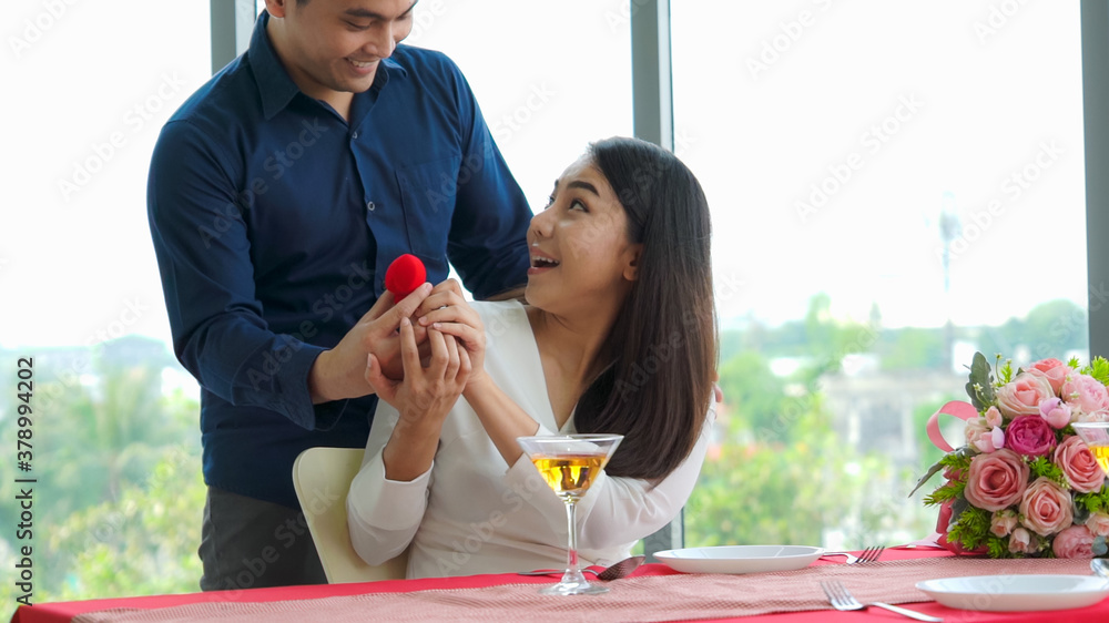 Romantic couple giving gift to lover at restaurant . Happy couple lifestyle .