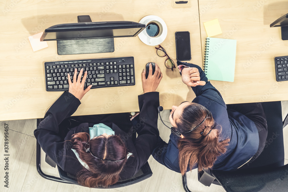 Business people wearing headset from top view in office working with computer to support remote cust