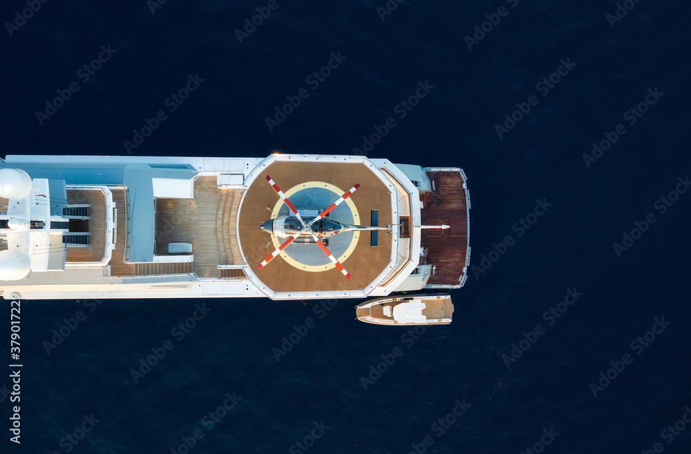 Air view of the helicopter on the deck of the yacht. Composition with sea transport. The sea and a y