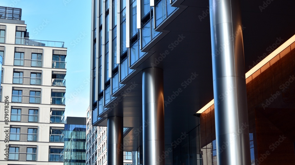 Blue curtain wall made of toned glass and steel constructions under blue sky. A fragment of a buildi